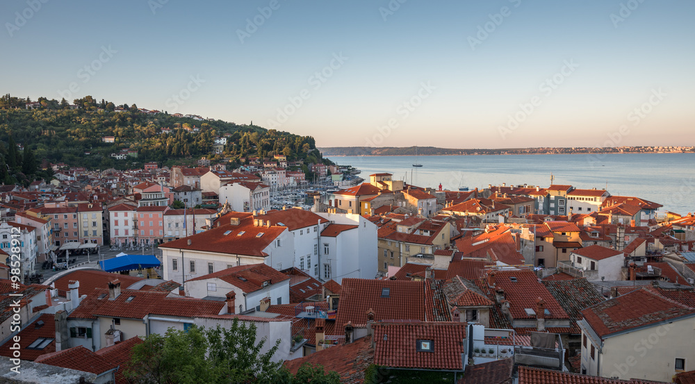 Sunlit Red Roofs of the Town Piran, Slovenia. View from Above at Sunrise.