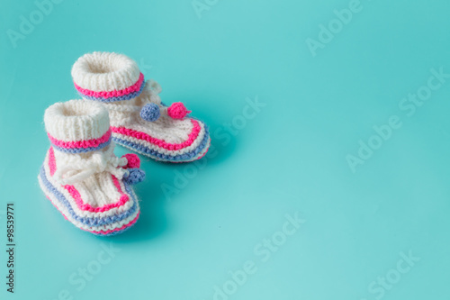 Baby birthday invitation. Knitted booties closeup view