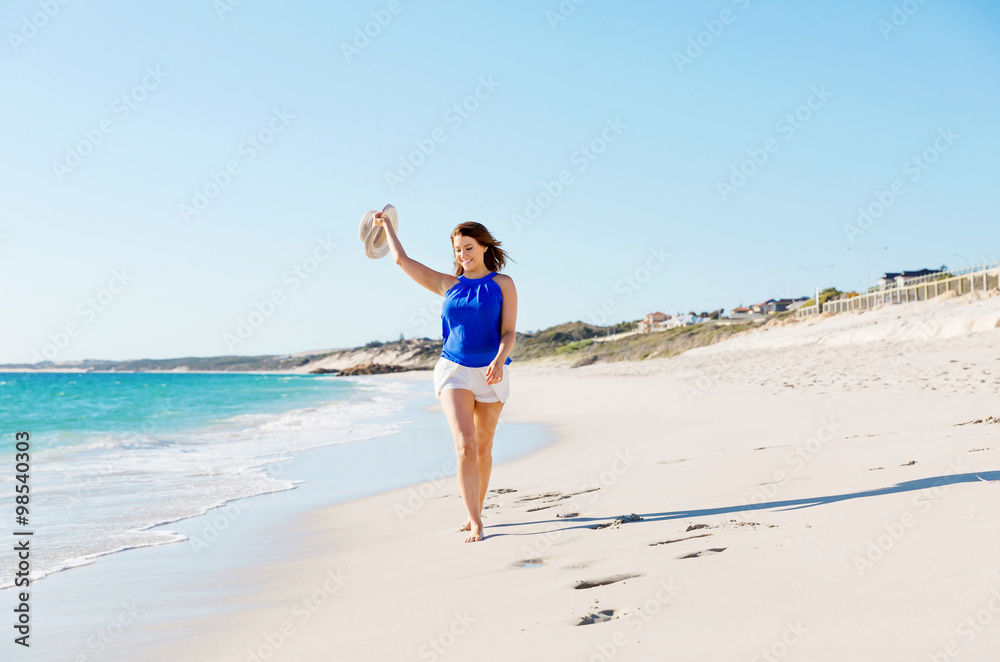 Young woman walking along the beach