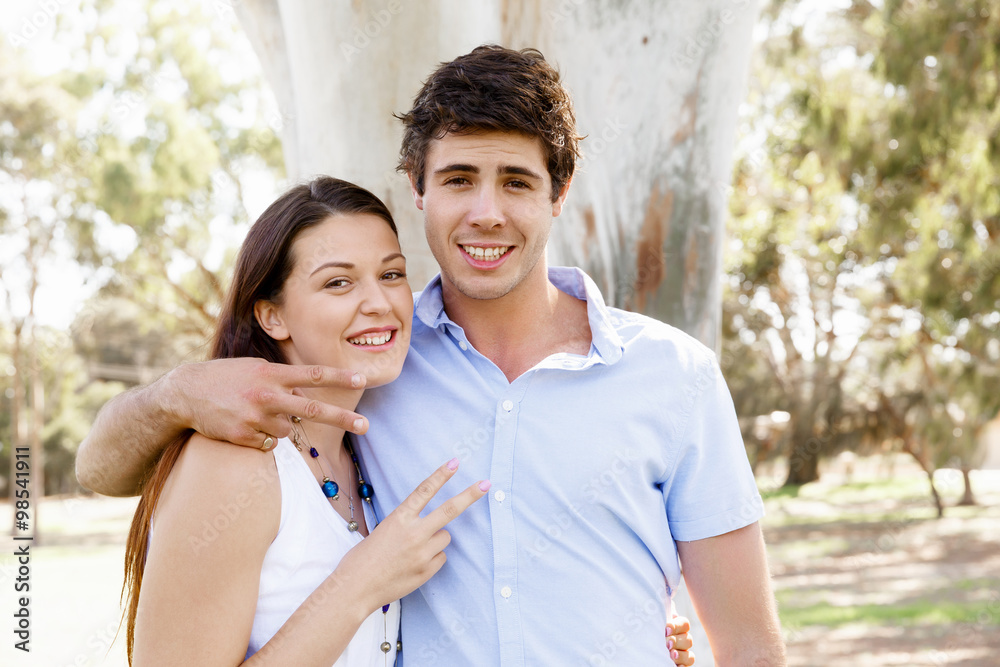 Young couple in the park celebrating