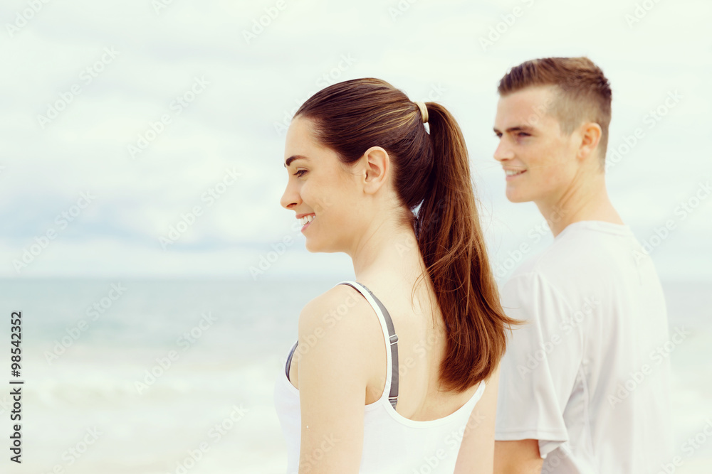 Young couple looking thoughtful while standing next to each other on beach Young couple looking thoughtful while standing next to each other on beach