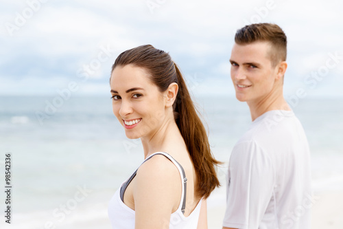 Young couple looking thoughtful while standing next to each other on beach