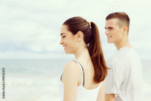 Young couple looking thoughtful while standing next to each other on beach