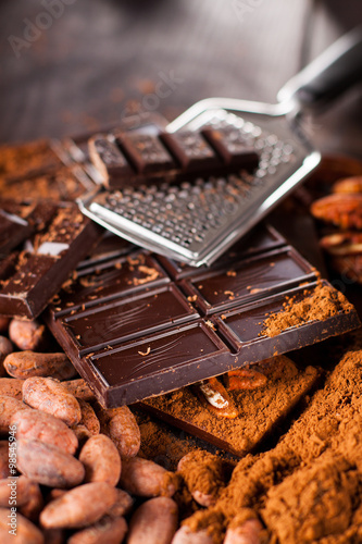 Chocolate products. Chocolate, cocoa beans, cocoa and nuts on wooden background. 