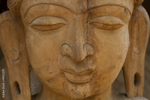 Wooden face. Face of Buddha. Face carved out of wood. 