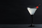 Cocktail in martini glass on the black wooden background