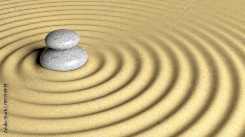Balancing Zen stones stack from large to small on sand with circular ripples.