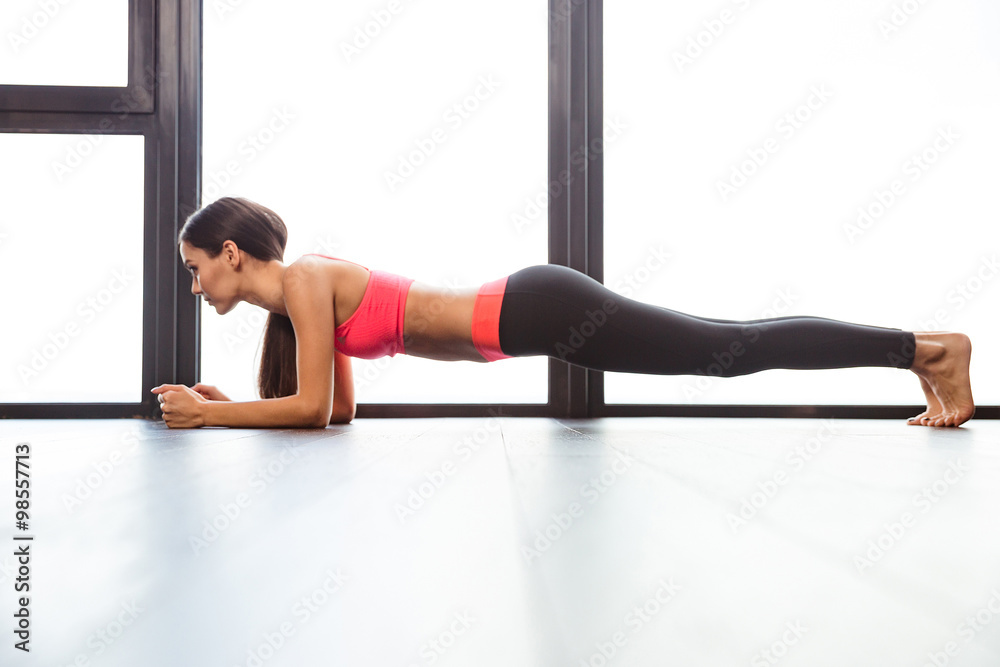 Photo of athletic beautiful woman doing exercise while working out Stock  Photo by vadymvdrobot