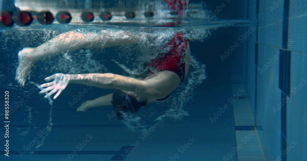 Underwater view of woman performing a flip turn in the swimming pool