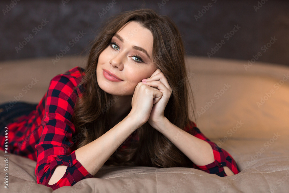 Woman lying on the bed and looking at camera Woman lying on the bed and looking at camera