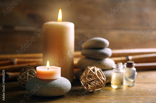 Decorated composition with candles  pebbles and bamboo on wooden background