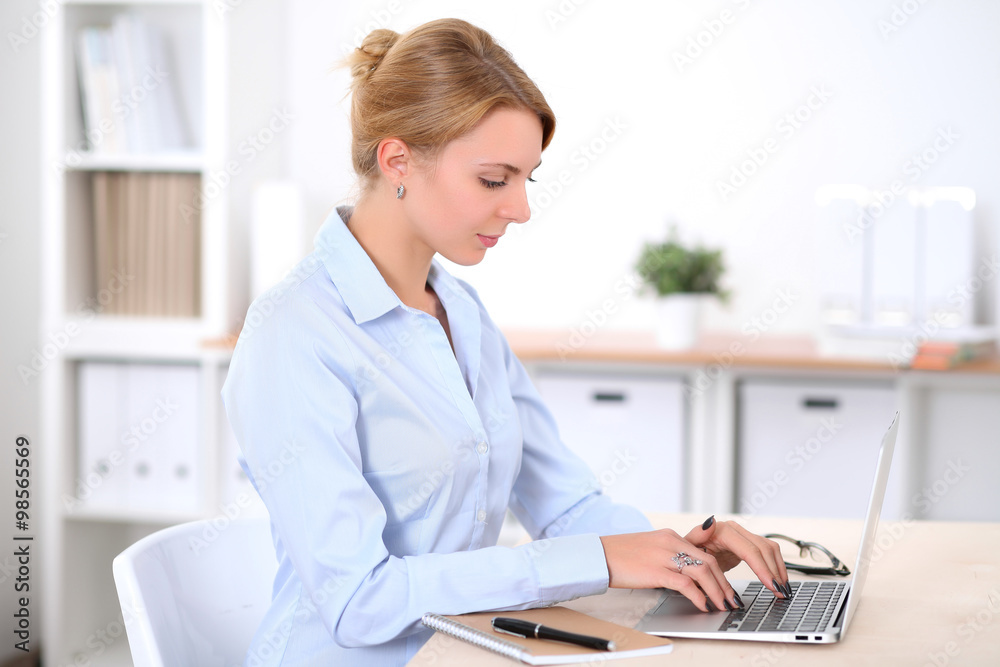 Young blonde business woman with laptop in the office. Business concept. Young blonde business woman with laptop in the office. Business concept.