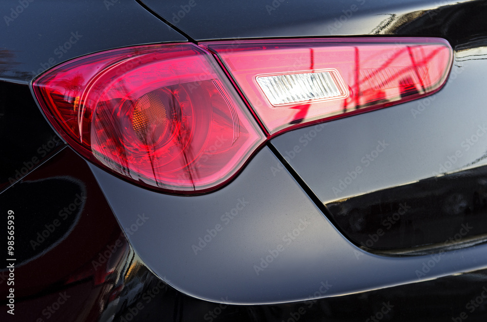 
Car back lights. Black metallic color vehicle rear part close up view from behind.