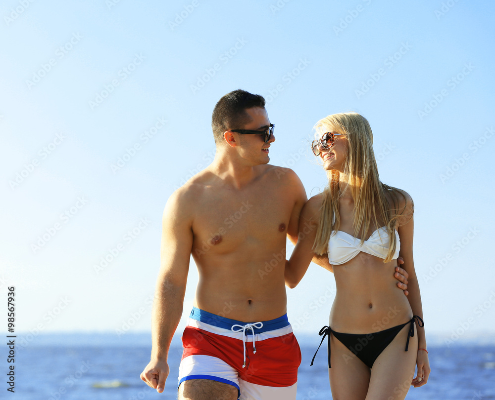 A hugging couple at the beach, on sky background