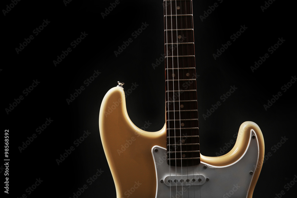 Part of white electric guitar, on black background