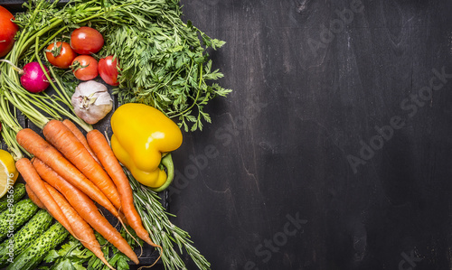 Colorful various of organic farm vegetables in a wooden box on wooden rustic background top view close up border ,place for text photo