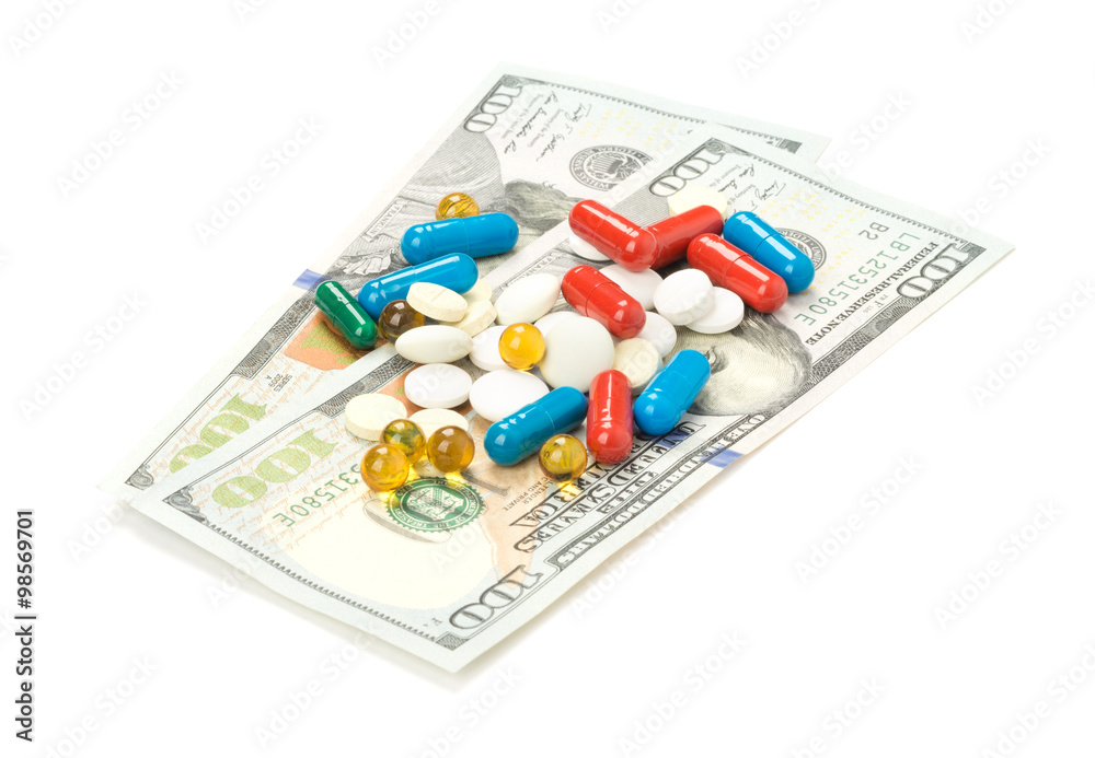 One hundred dollars banknotes and pill isolated on white background One hundred dollars banknotes and pill isolated on white background