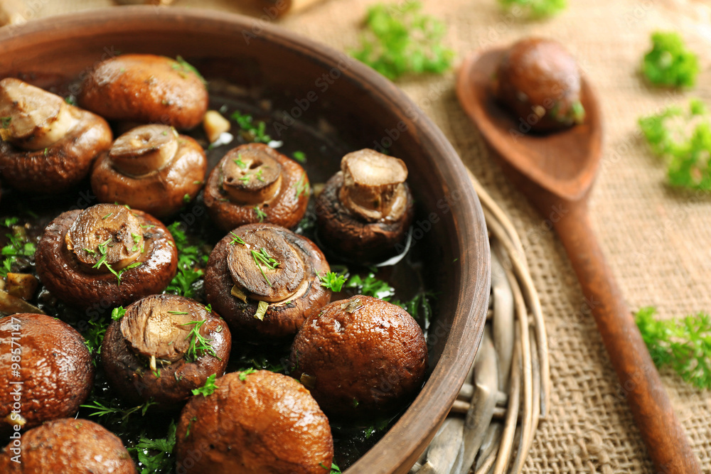 Baked champignons mushrooms with butter, parsley and roasted garlic in brown bowl Baked champignons mushrooms with butter, parsley and roasted garlic in brown bowl