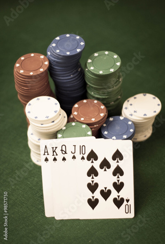 Cards and stack of poker chips and on a green background 