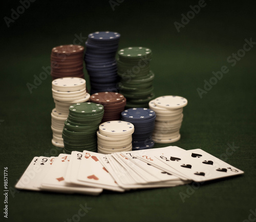 Cards and stack of poker chips and on a green background 