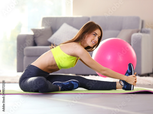 Beautiful young girl doing exercises at home