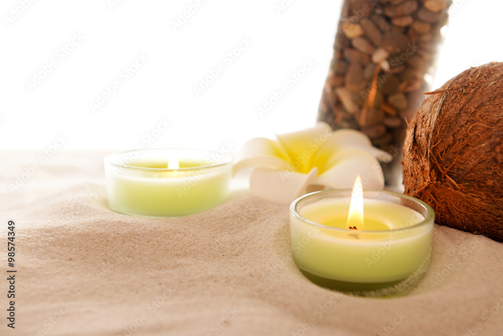 Plumeria with burning candles, coconut and bottle on sand, isolated on white Plumeria with burning candles, coconut and bottle on sand, isolated on white