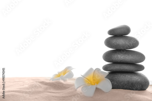 Few spa stones with plumeria on sand  isolated on white