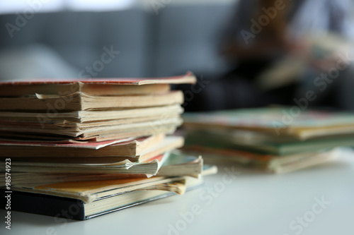 Pile of old books on white table. Focus on books and blurred background