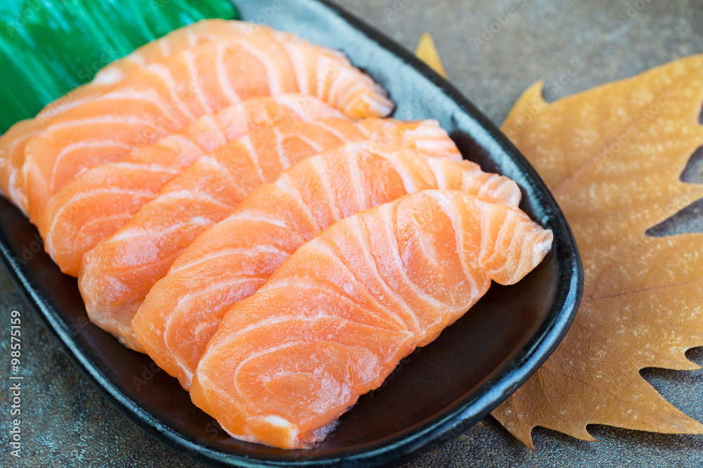 Sliced raw salmon on black plate Sliced raw salmon on black plate