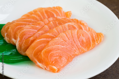 Sliced raw salmon on white plate