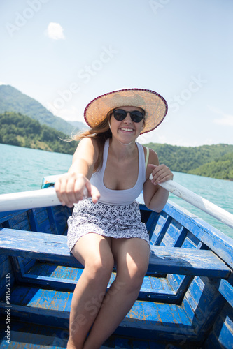 A young woman is rowing a boat on a summer day © Myvisuals
