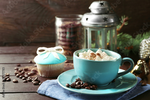 Mug of hot chocolate with marshmallows, fir tree branch on wooden background