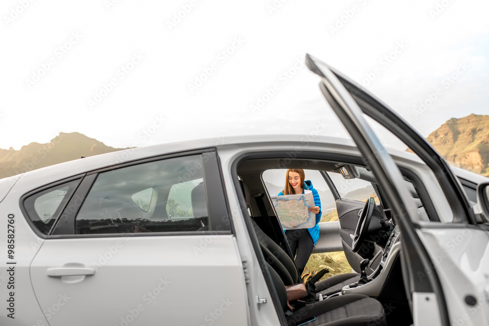 Female traveler with toursit map near the car Female traveler with toursit map near the car