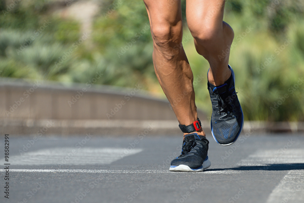 Runner feet running on road closeup on shoe Runner feet running on road closeup on shoe