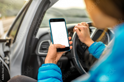 Woman using smartphone driving the car