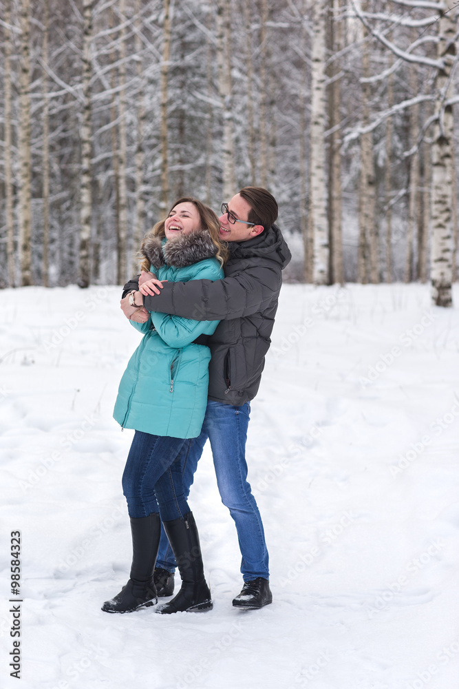 Young beautiful couple walking in winter forest Young beautiful couple walking in winter forest