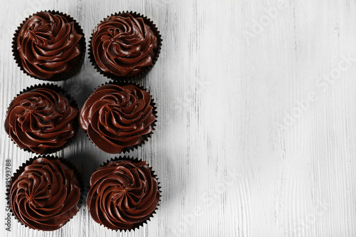 Chocolate cupcakes on light wooden background
