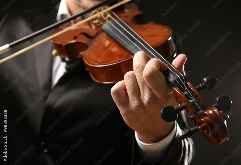 Musician play violin on black background, close up Musician play violin on black background, close up