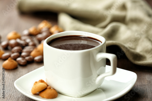 Cup of cacao with biscuits on wooden background