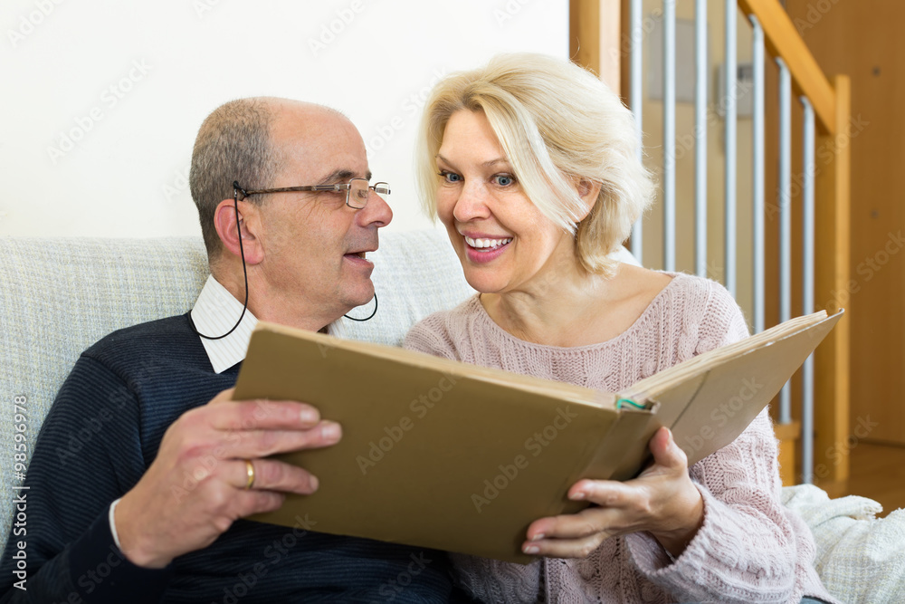 Senior spouses with picture album indoor