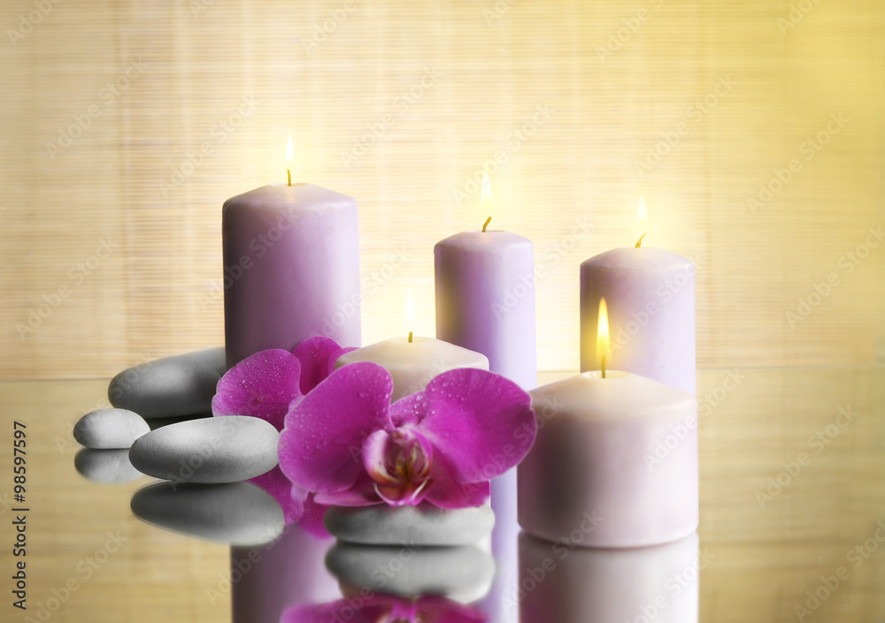 Spa composition with candles, pebbles and flowers on the table, close up Spa composition with candles, pebbles and flowers on the table, close up