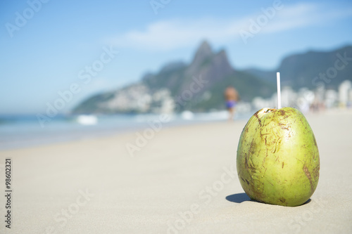 Green coconut coco gelado on Ipanema Beach against a backdrop of Two Brothers Dois Irmaos Mountain in Rio de Janeiro, Brazil