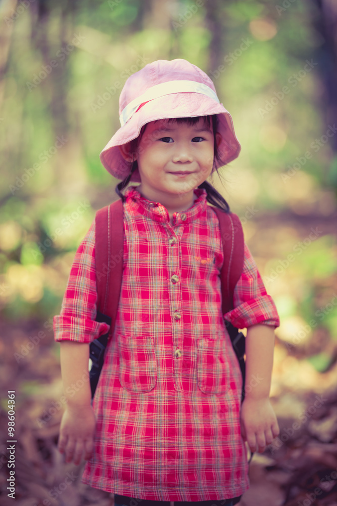 Cute little asian girl looking at camera and smiling over nature background Cute little asian girl looking at camera and smiling over nature background
