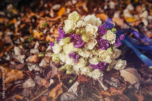 wedding bouquet lies on the fall foliage