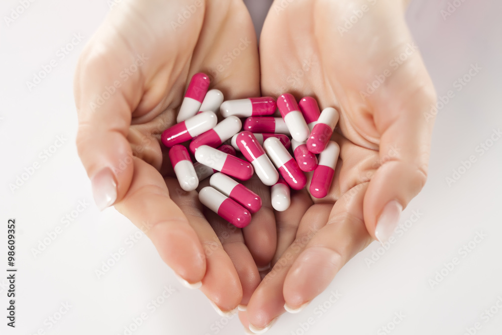 fists full of pills on a white background fists full of pills on a white background
