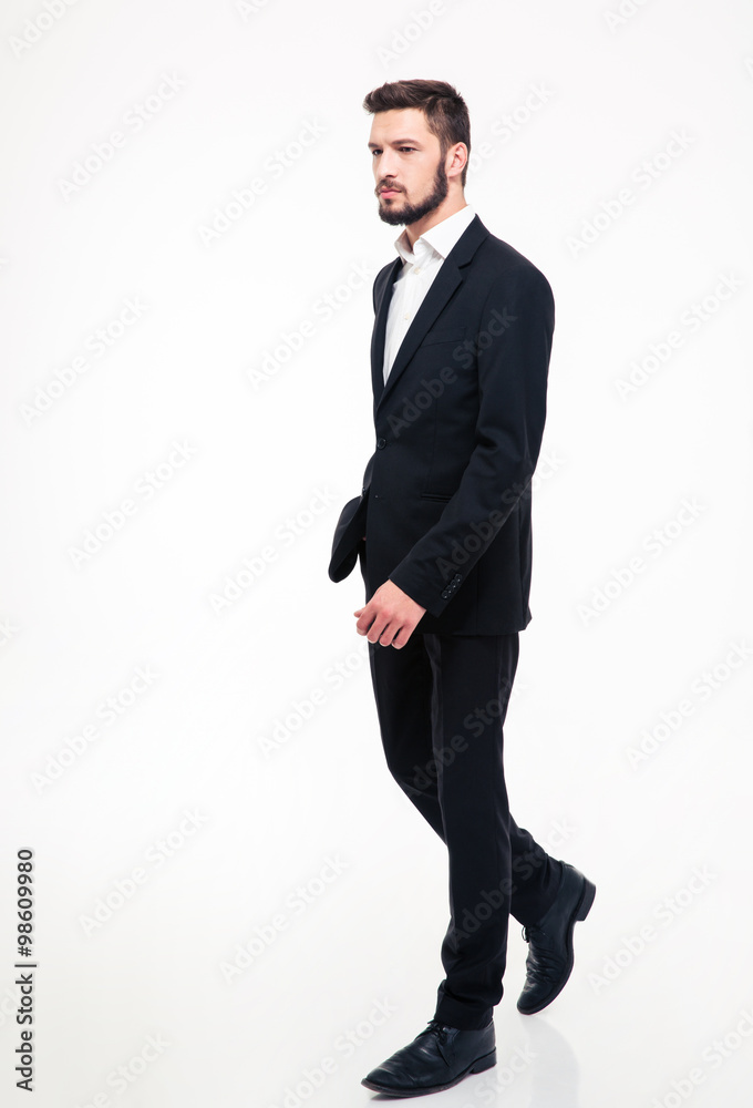 Full length portrait of a handsome businessman walking i