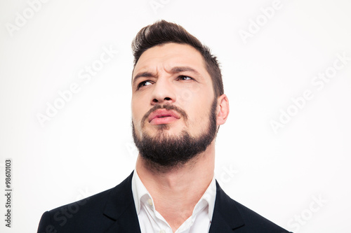 Handsome frowning young businessman with beard looking away