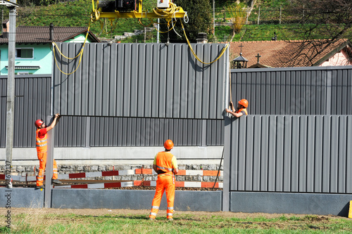 Workers during the installation of noise barriers on the railway photo