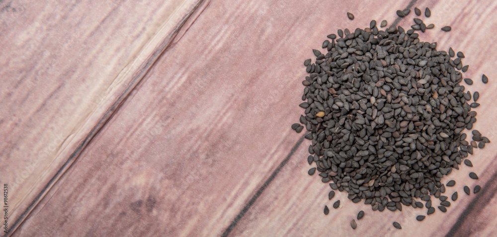 Black sesame seed over wooden background Black sesame seed over wooden background
