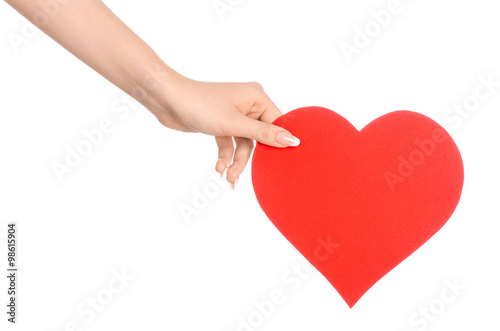 Love and greetings card theme: beautiful female hand holding a paper card red heart isolated on a white background in studio